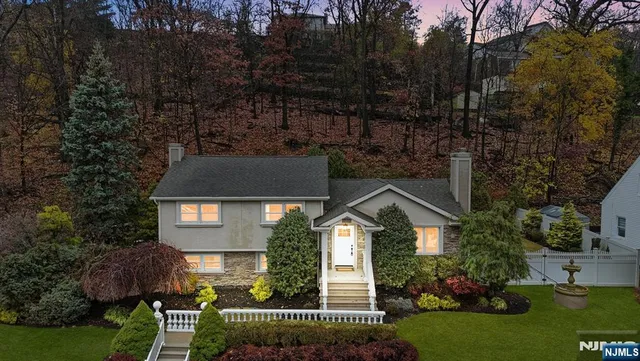 a front view of a house with a yard and potted plants