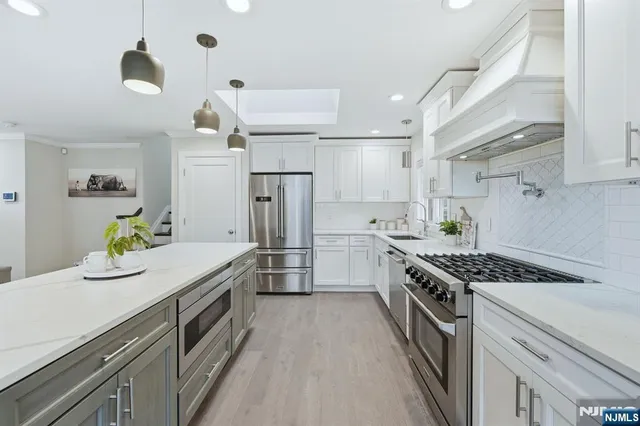 a kitchen with stainless steel appliances a stove a refrigerator and a sink