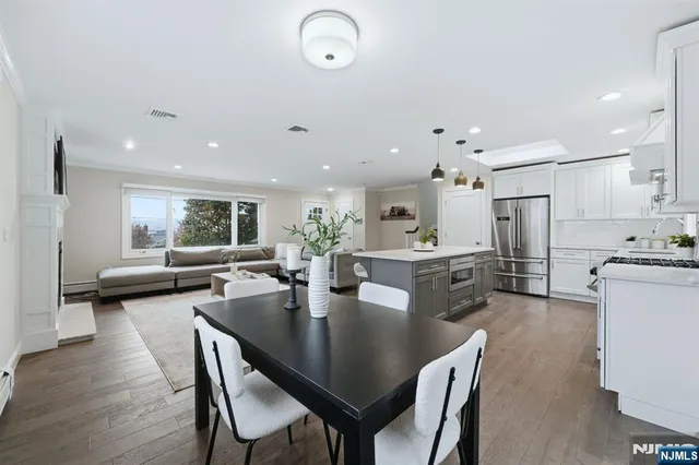 a dining room with stainless steel appliances kitchen island granite countertop a sink a stove a dining table and chairs