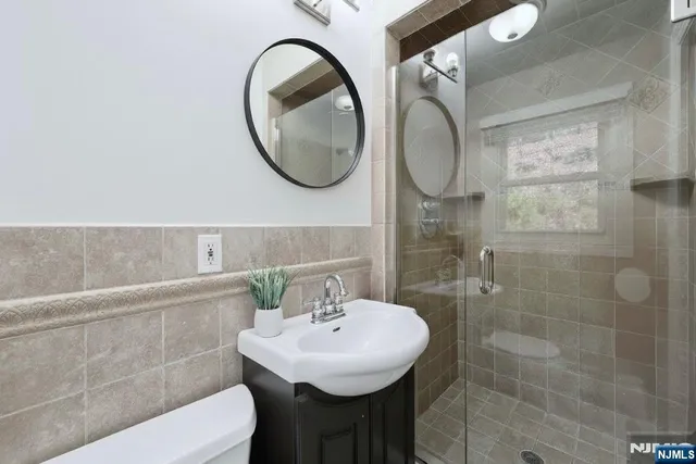 a bathroom with a sink a toilet and a mirror