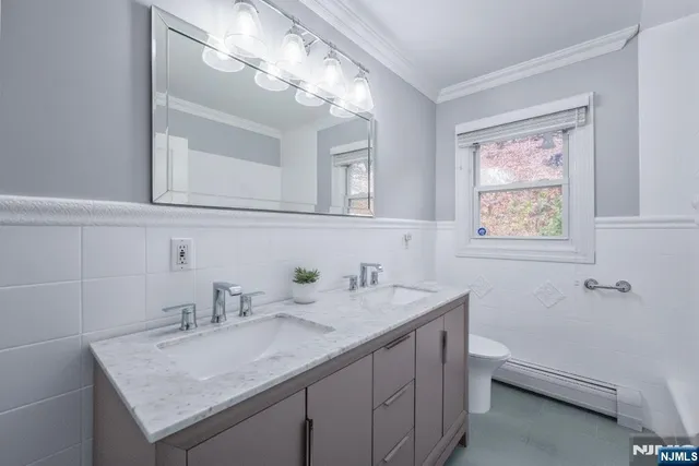 a bathroom with a granite countertop sink a toilet and a mirror