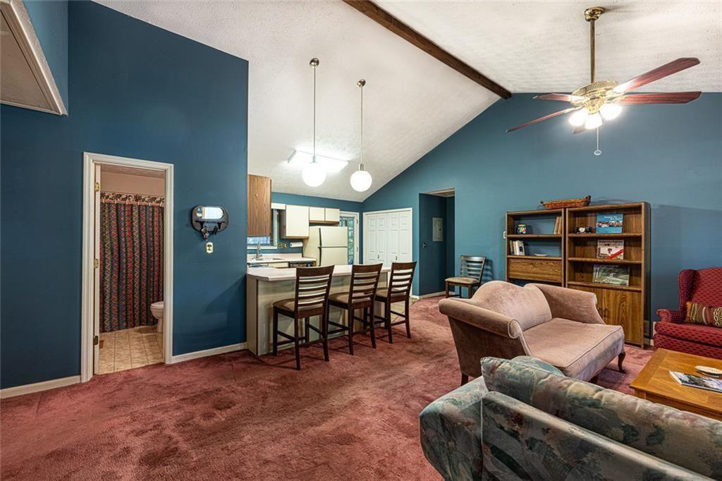 633 Iris Road Pine Lake, GA 30072 - Photo 11 of 39 a living room with furniture a chandelier and a flat screen tv