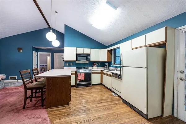 a kitchen with refrigerator and cabinets