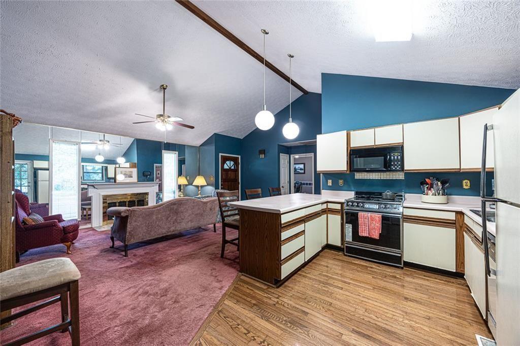 633 Iris Road Pine Lake, GA 30072 - Photo 14 of 39 a large living room with stainless steel appliances granite countertop couches a flat screen tv and kitchen view