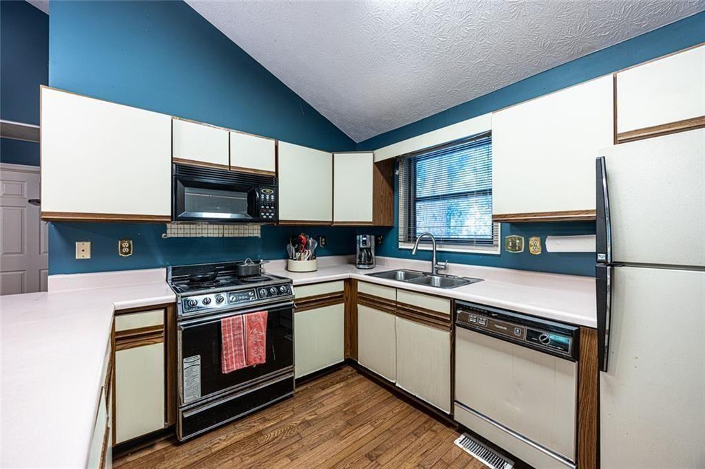 633 Iris Road Pine Lake, GA 30072 - Photo 15 of 39 a kitchen with stainless steel appliances granite countertop a stove a sink and a microwave
