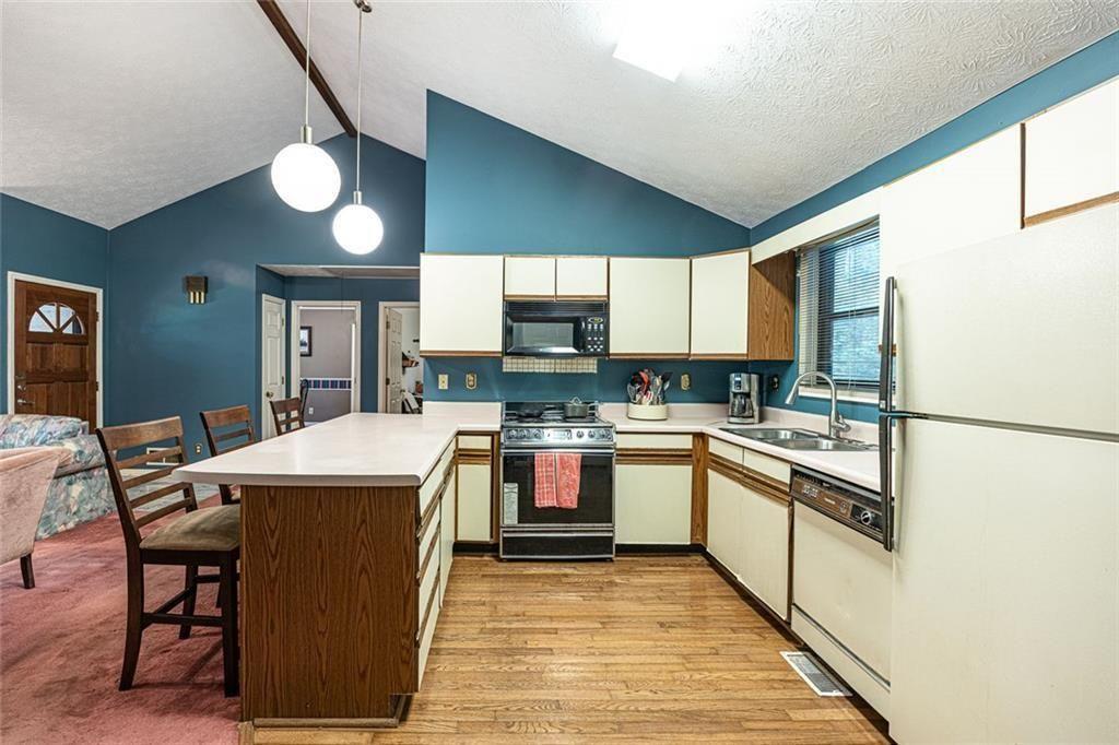 633 Iris Road Pine Lake, GA 30072 - Photo 25 of 39 a kitchen with stainless steel appliances granite countertop a stove a sink dishwasher and a refrigerator with wooden cabinets