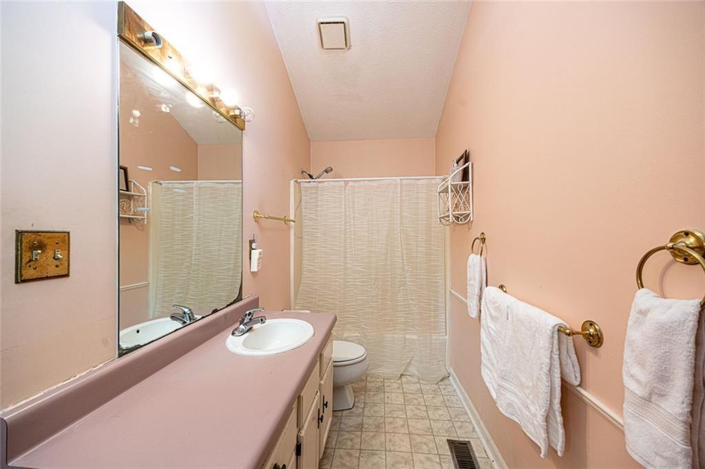 633 Iris Road Pine Lake, GA 30072 - Photo 34 of 39 a bathroom with a double vanity sink toilet mirror and shower