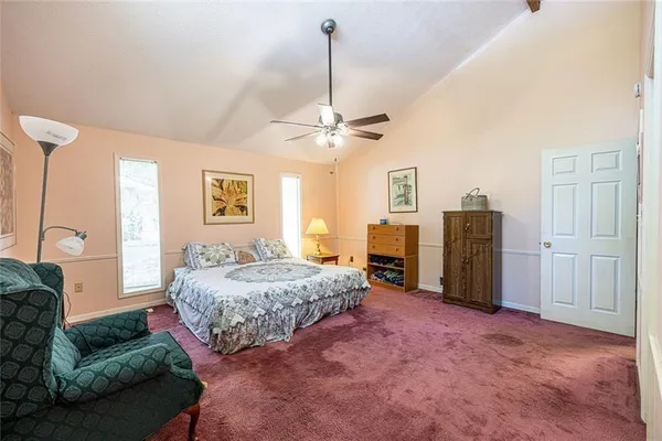 a spacious bedroom with a bed dresser and a window