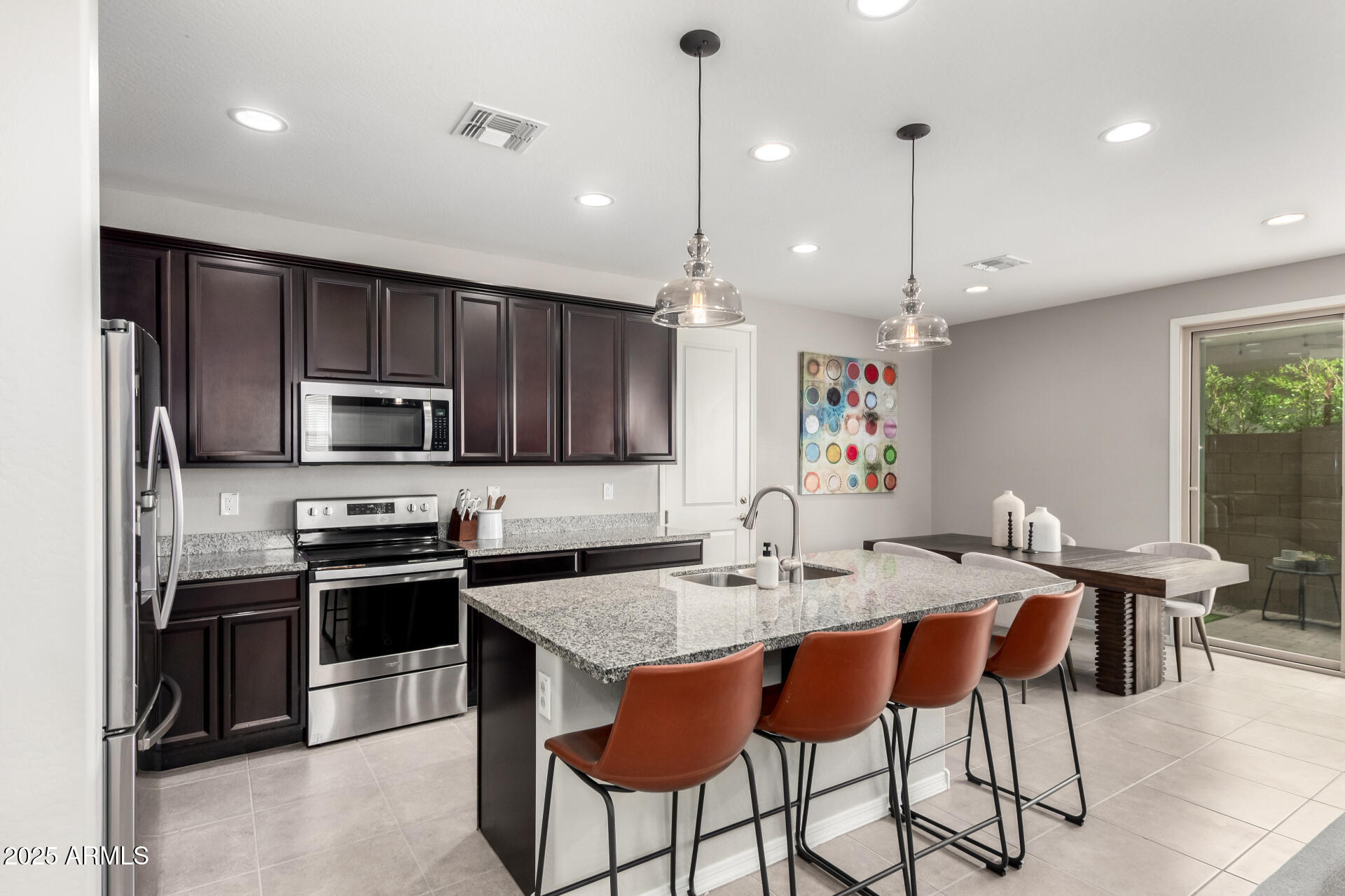 17160 North 9th Place Phoenix, AZ 85022 - Photo 12 of 46 a kitchen with stainless steel appliances kitchen island granite countertop a table chairs microwave and sink