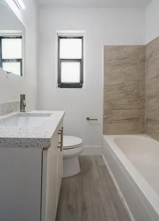 a bathroom with a granite countertop sink toilet and bathtub