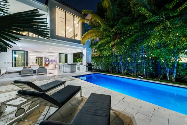 a dining room with furniture a large window and a chandelier