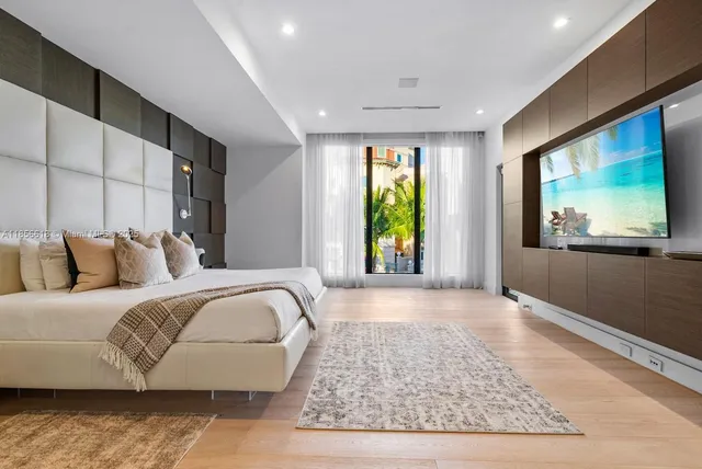 a living room with furniture a potted plant and a flat screen tv