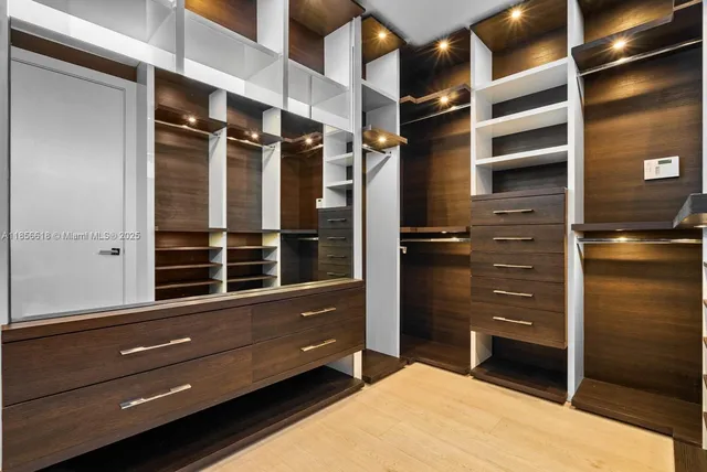 a hallway with white cabinets and wooden floor