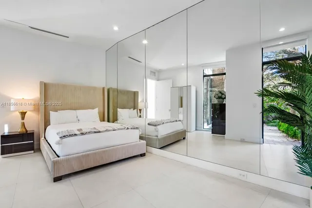 a bedroom with a bed a couch and a flat screen tv