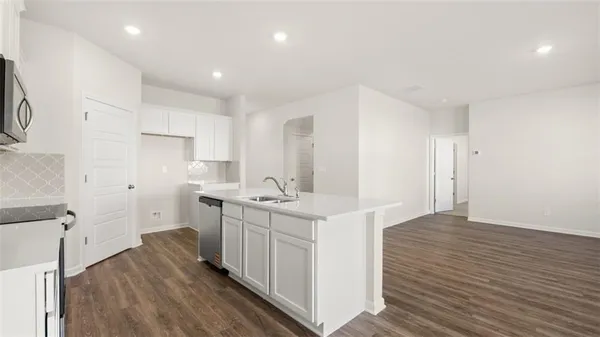 a kitchen with white cabinets appliances and sink