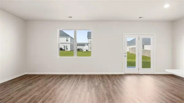 an empty room with wooden floor and window