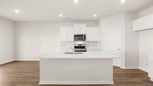 a kitchen with stainless steel appliances a refrigerator sink and white cabinets