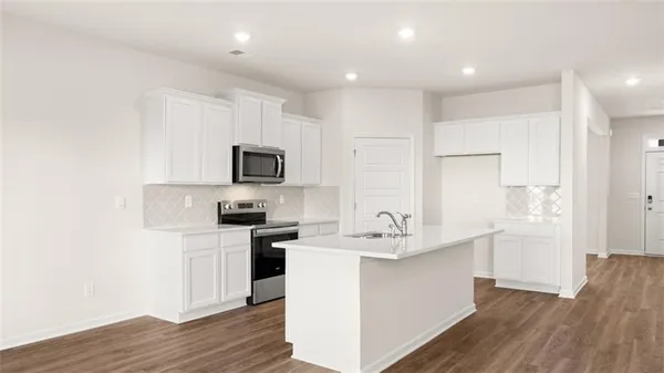 a kitchen with a sink stainless steel appliances and white cabinets