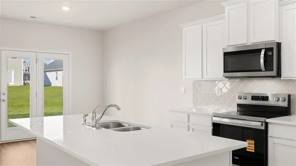 a kitchen with stainless steel appliances a sink a stove a microwave and cabinets