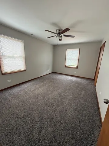 an empty room with a ceiling fan and a window