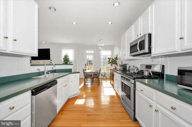 a large kitchen with stainless steel appliances lots of counter space and a sink