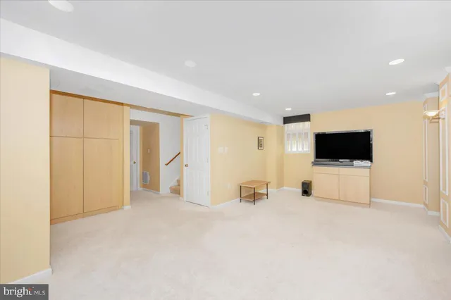 a view of a livingroom with an empty room and kitchen with sink