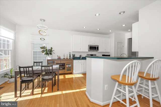 a kitchen with stainless steel appliances kitchen island granite countertop a table and chairs in it