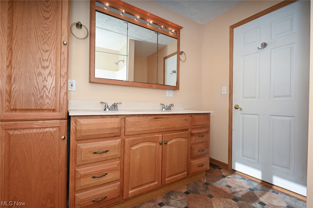 1509 McTaggart Road Stow, OH 44224 - Photo 22 of 30 Bathroom with double vanity, a textured ceiling, and tile floors