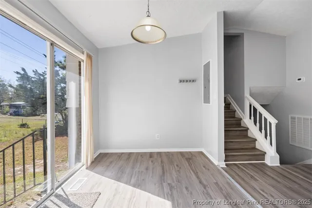 a view of a hallway with wooden floor and entryway