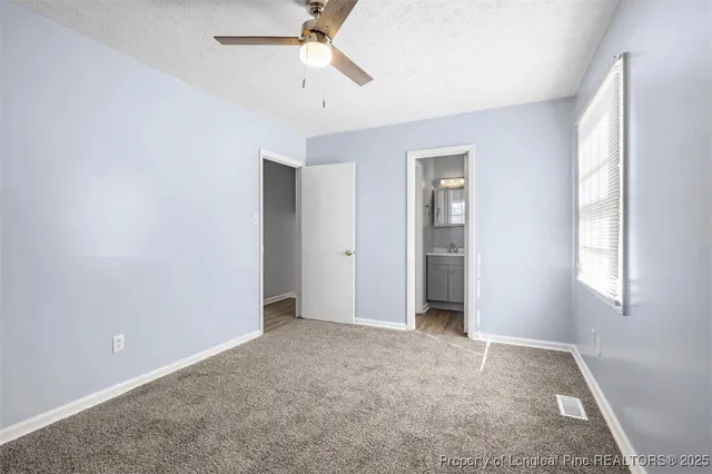 an empty room with fan and windows