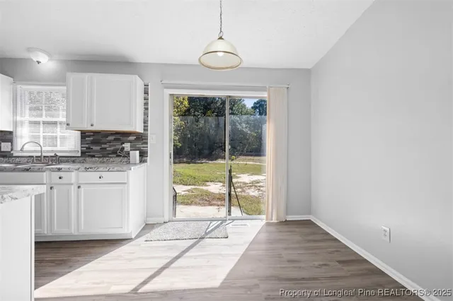 a view of a kitchen with granite countertop a sink and a stove top oven