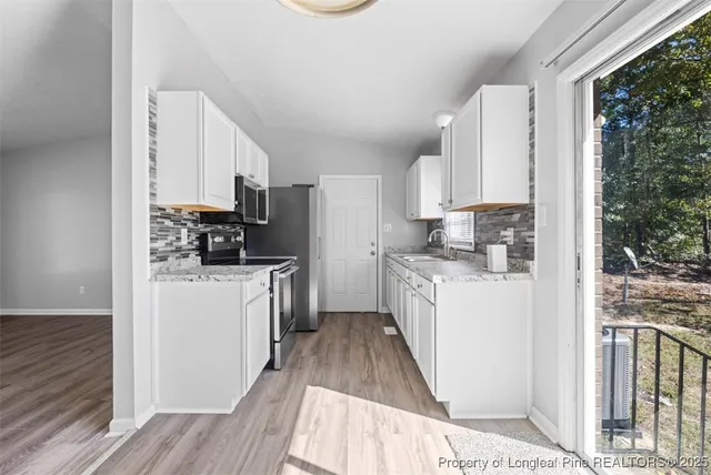 a kitchen with a refrigerator a stove top oven a sink dishwasher and wooden cabinets