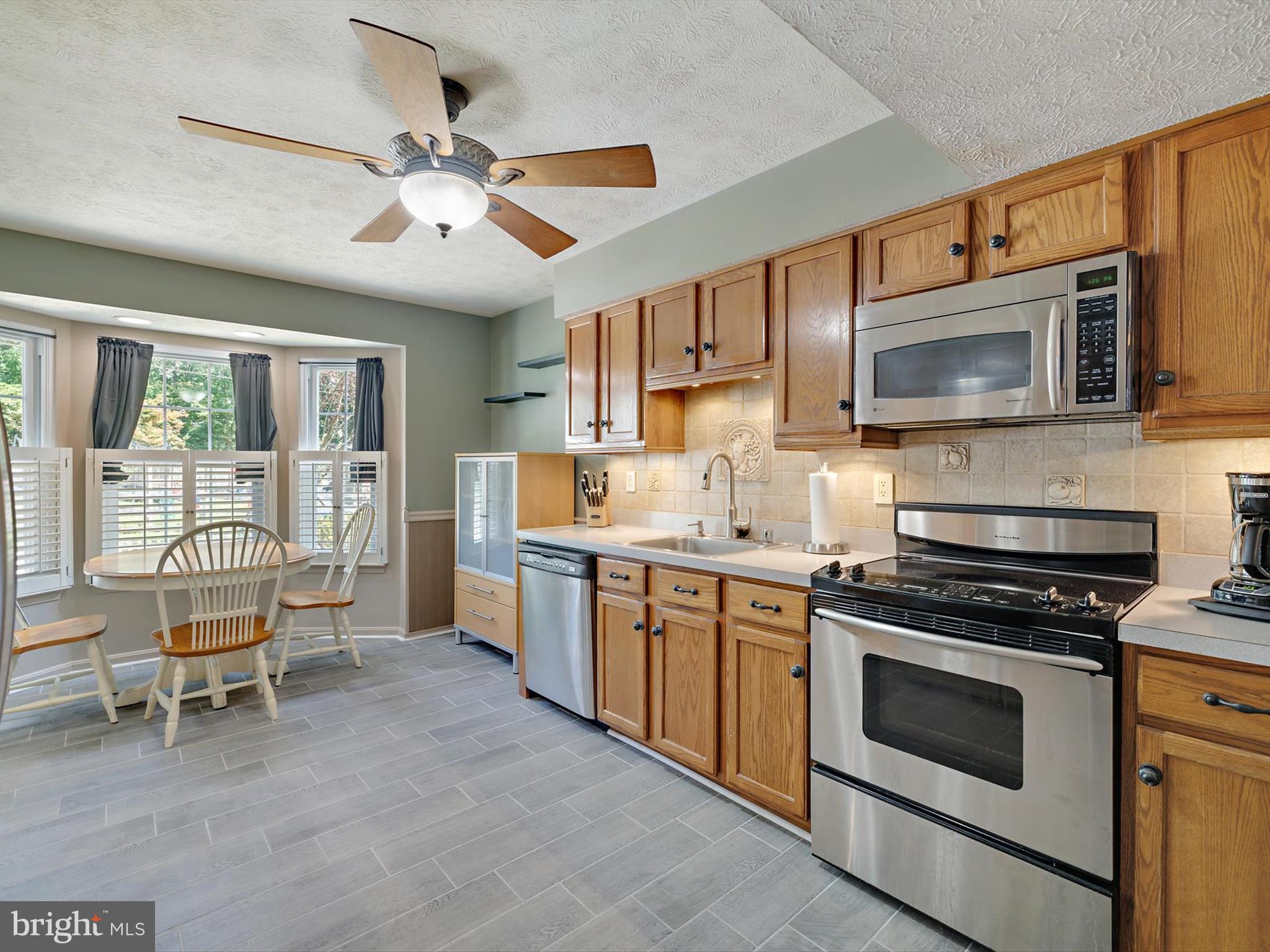7824 Camp Road Pasadena, MD 21122 - Photo 8 of 33 a kitchen with granite countertop a stove top oven cabinets a sink and a counter top space