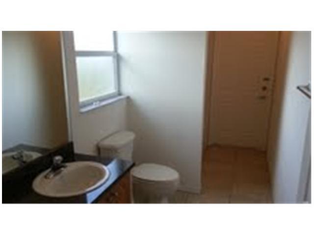 694 Southwest Heather Street Port St. Lucie, FL 34983 - Photo 11 of 13 a bathroom with a sink toilet and mirror