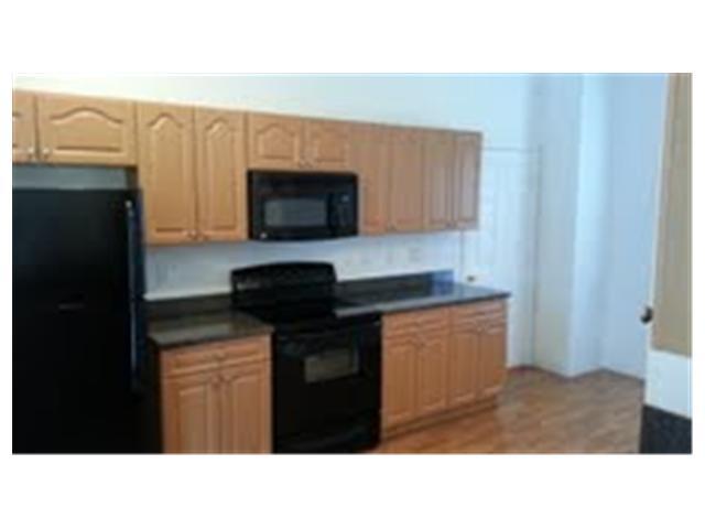 694 Southwest Heather Street Port St. Lucie, FL 34983 - Photo 2 of 13 a kitchen with a sink a microwave a refrigerator and cabinets