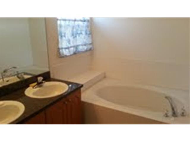 694 Southwest Heather Street Port St. Lucie, FL 34983 - Photo 7 of 13 a bathroom with a sink vanity mirror and bathtub