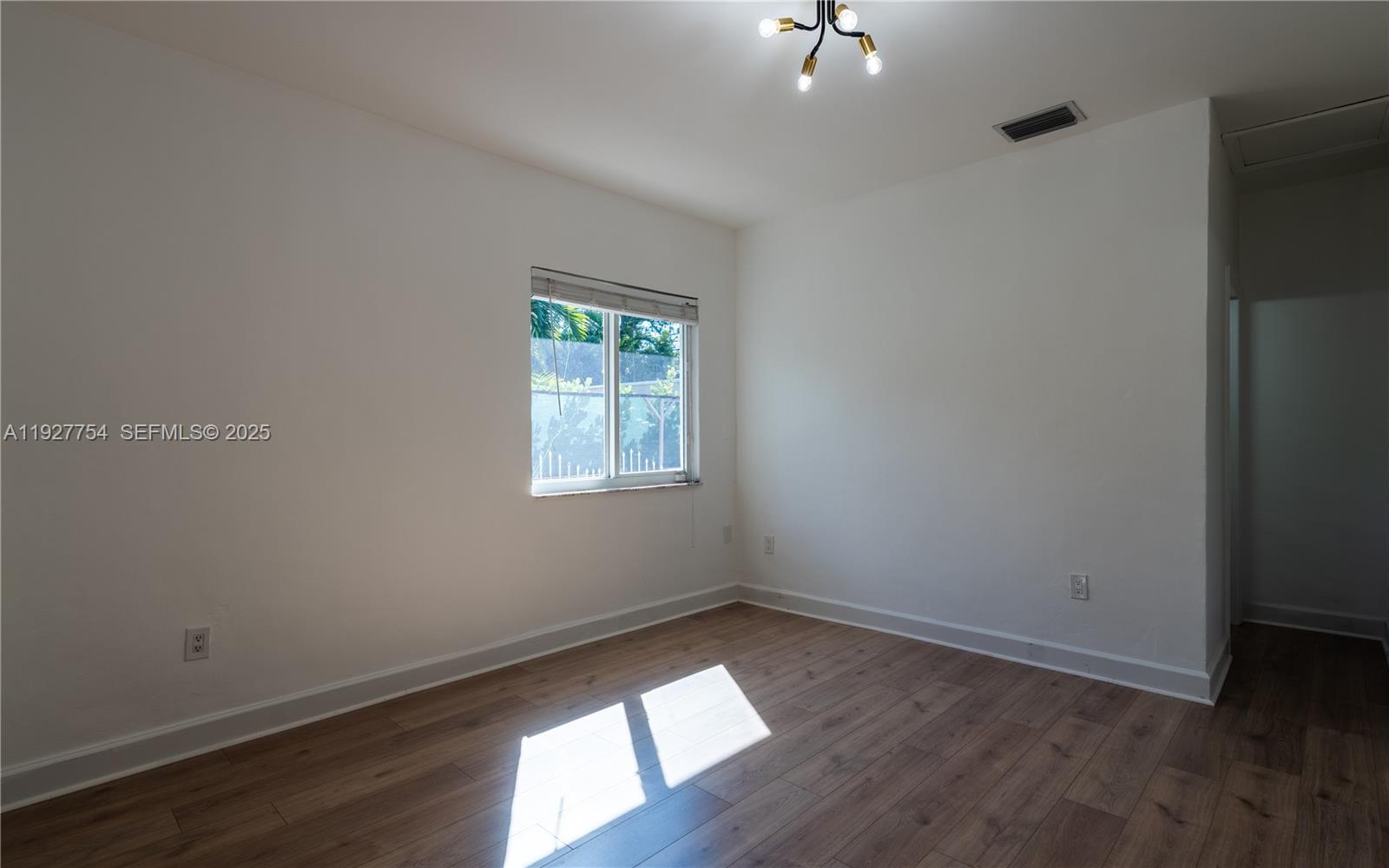 426 Southwest 26th Road Miami, FL 33129 - Photo 5 of 13 an empty room with wooden floor and windows