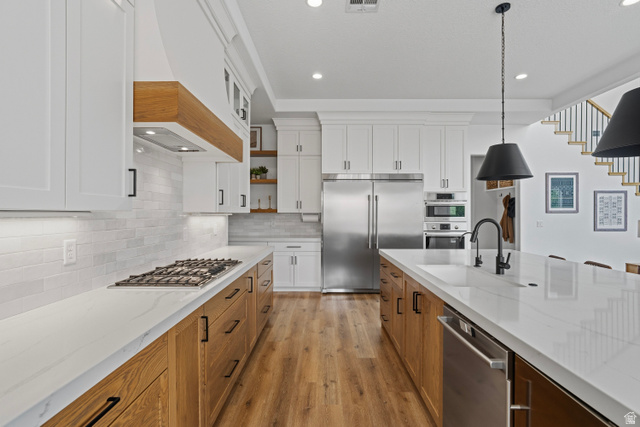 2278 Tawny Ridge Circle St. George, UT 84790 - Photo 13 of 61 Spacious kitchen featuring white upper cabinetry, wood-finish lower cabinetry, and light-colored countertops.