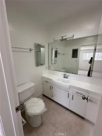 a bathroom with a granite countertop toilet sink and mirror