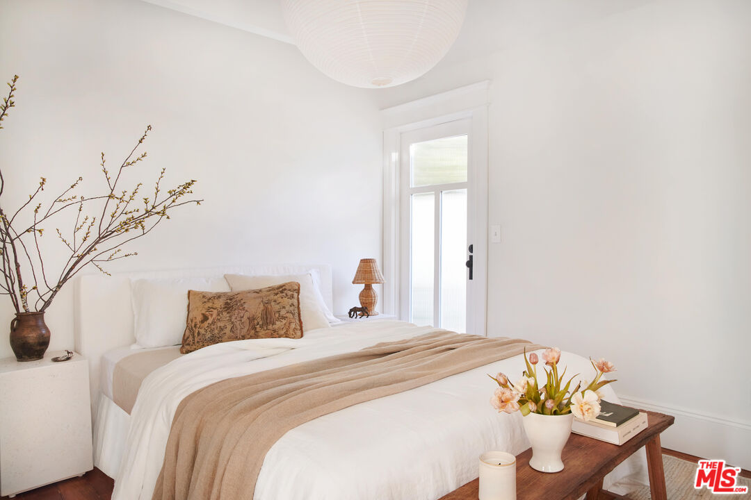 6506 Ruby Street Los Angeles, CA 90042 - Photo 15 of 21 a bedroom with a bed and a chandelier