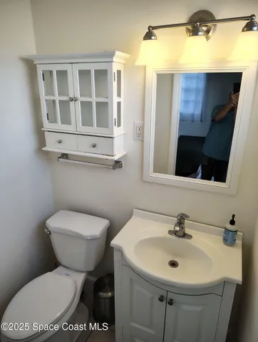 a bathroom with a toilet sink and mirror