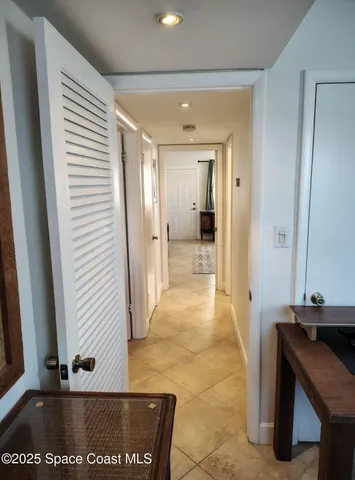 a view of a hallway with a door and couch