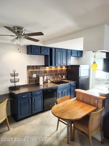 a kitchen with stainless steel appliances granite countertop a sink a stove a dining table and chairs