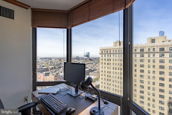a view of a workspace with furniture and a window