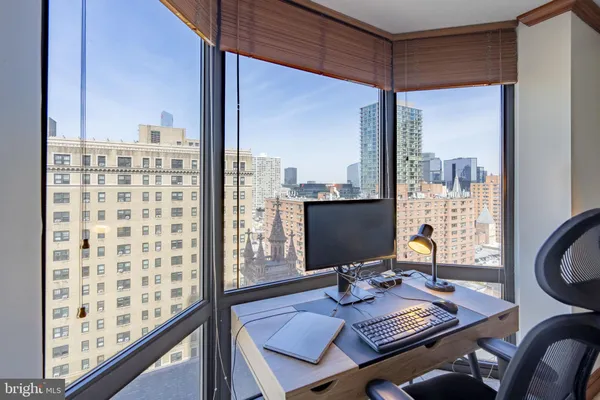 a view of a workspace with furniture and a window
