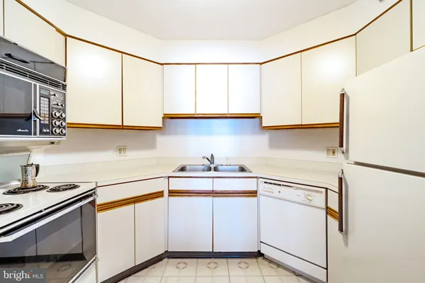 a kitchen with white cabinets and white appliances