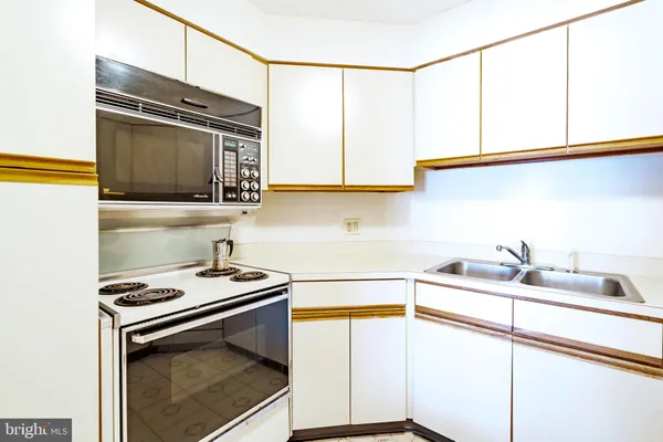 a kitchen with a sink stove and microwave