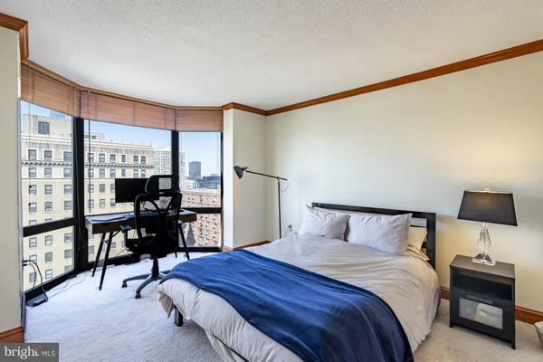 a bedroom with a bed and large window