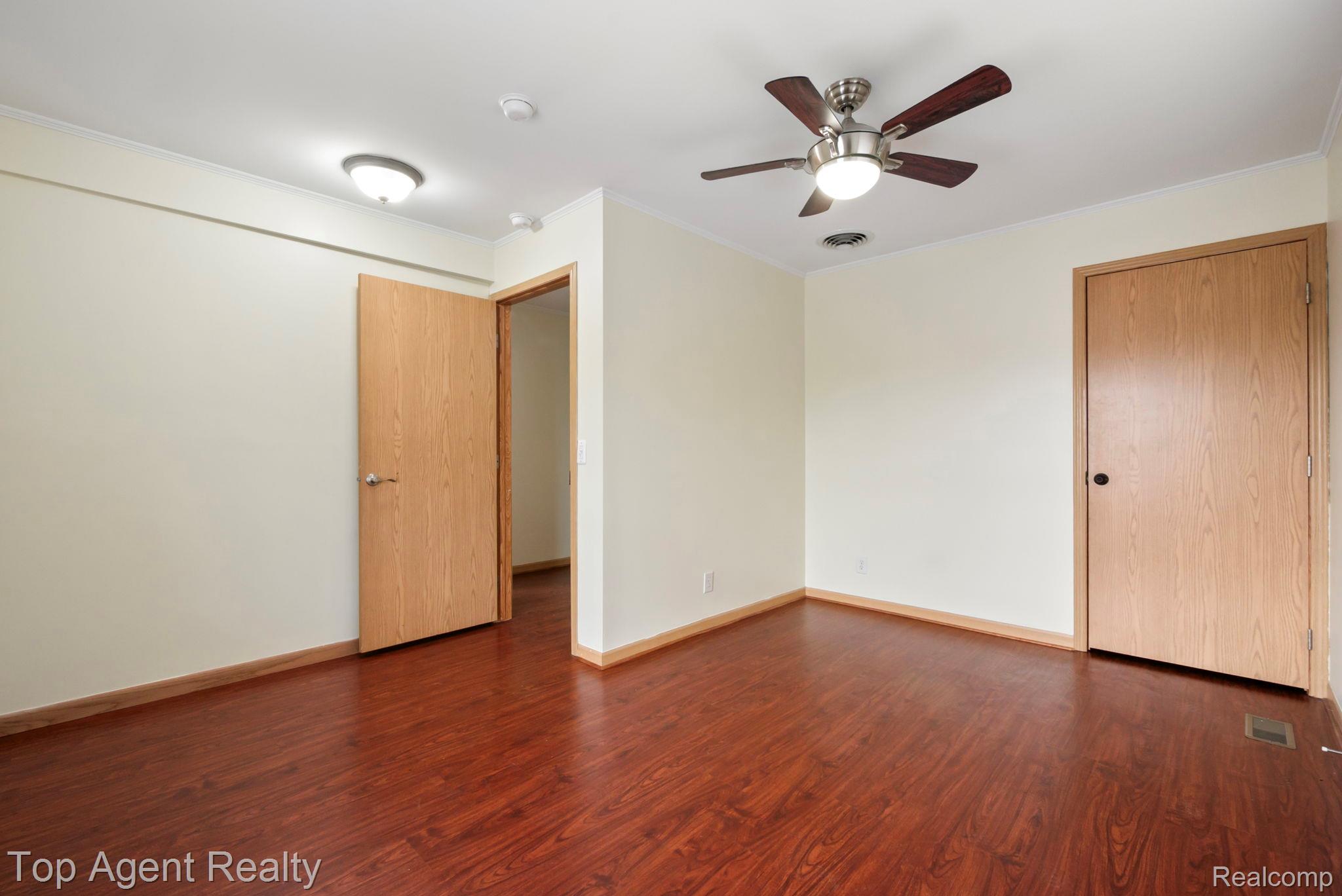 2018 John R Road Troy, MI 48083 - Photo 13 of 30 Unfurnished room with dark wood-style flooring, crown molding, and ceiling fan