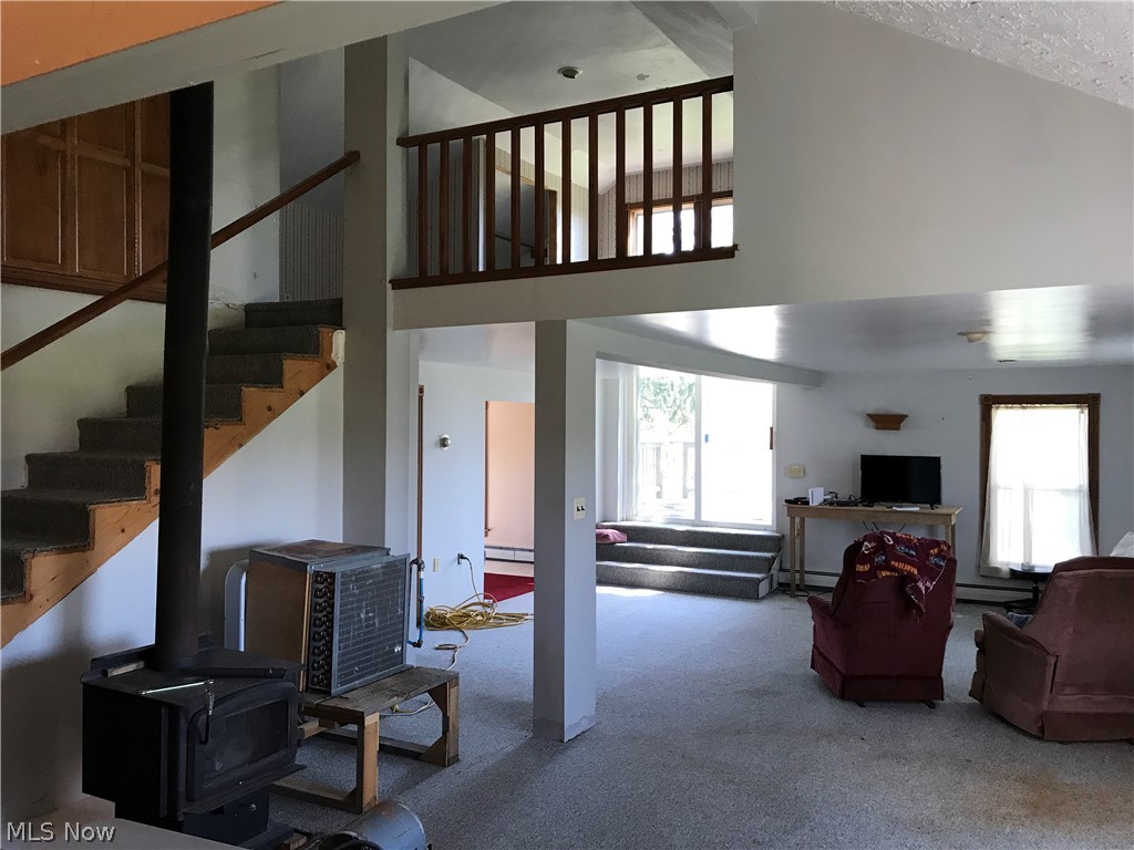 11850 Hunt Road Huntsburg, OH 44046 - Photo 4 of 26 Second level with stairs up to the loft. Sliding door access to outdoor deck. Woodburner stays. Heat exchanger for the hot water heat is on the platform next to the woodburner.